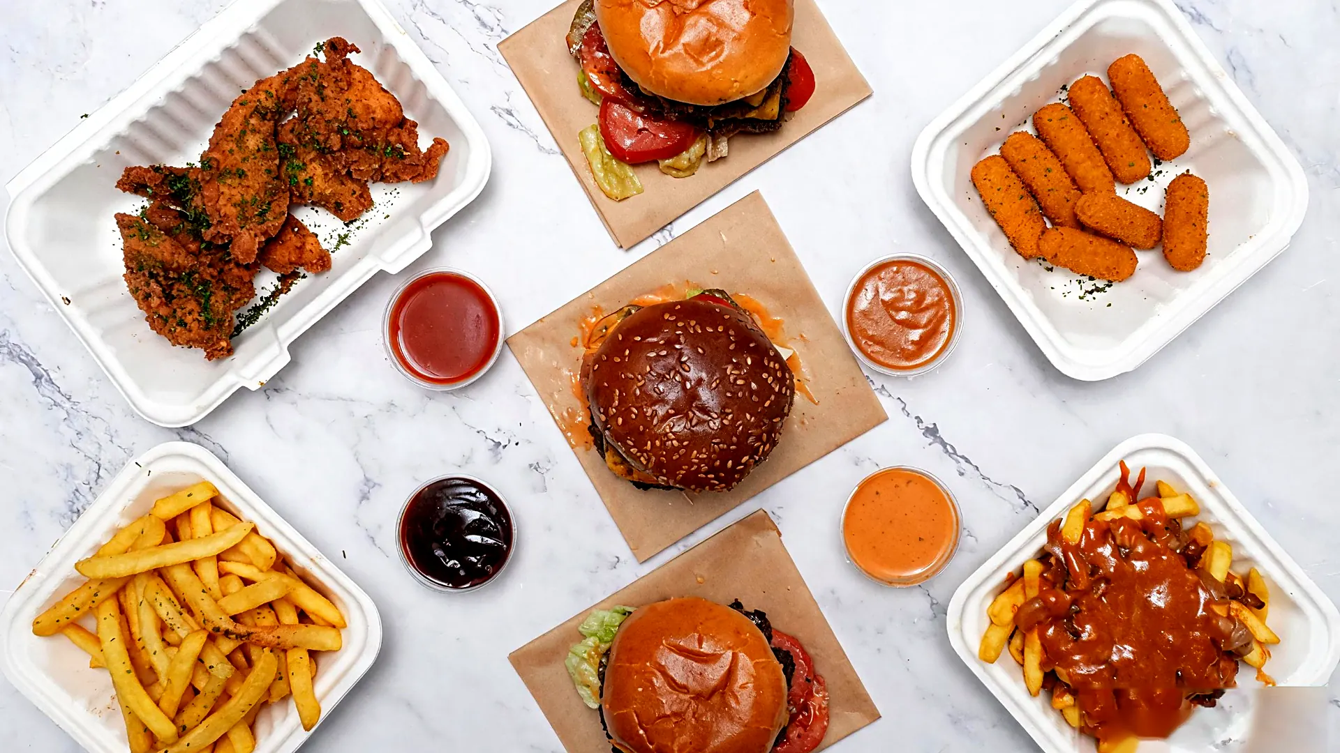 A Patty Stack spread: burgers, chips, chicken tenders, mozzarella sticks, loaded fries and dips